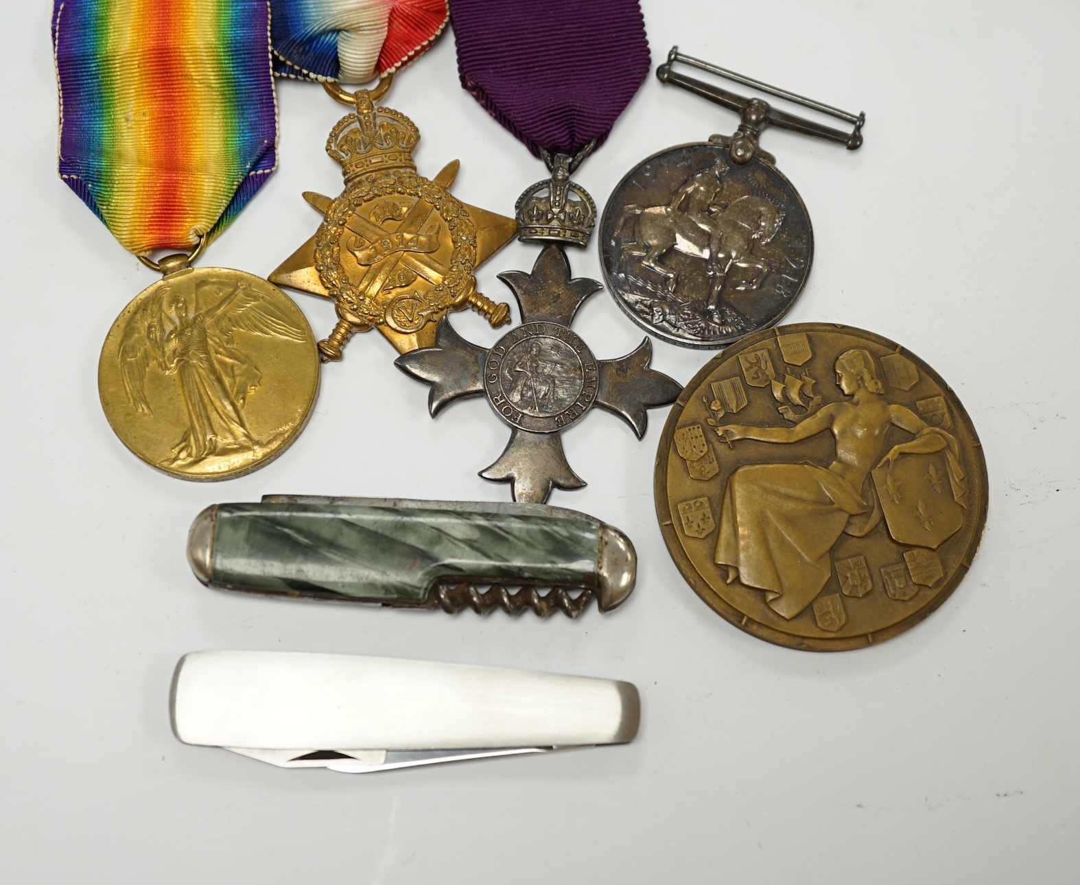 A First World War medal group awarded to Pte. G. Legh-Jones 1/28 London Regiment, comprising; an OBE with First War trio, together with a French Line ‘Ile de France’ commemorative medallion and two penknives. Condition -